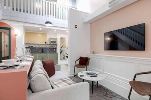 A cozy living room with sofa and a smart TV. - Chic Oasis above a resto on trendy Queen West! (Toronto)