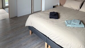 Une chambre à coucher comprenant un lit, une armoire et un appareil de climatisation.