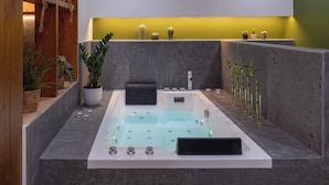 Ein modernes Badezimmer mit einer großzügigen Badewanne, Topfpflanzen und einem minimalistischen Design.
