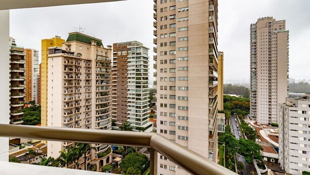 A high-rise residential building with multiple balconies and a view of surrounding high-rise buildings. - Apto com Piscina e Garagem Perto do Ibirapuera (São Paulo)