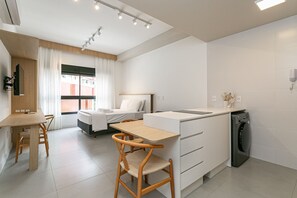 Una cocina moderna y funcional con comedor, lavadora y cama con vistas.