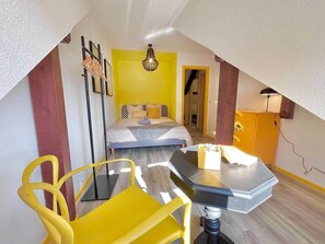 Ein Zimmer mit einem Bett, einem Schreibtisch, einem Stuhl und einer Lampe.