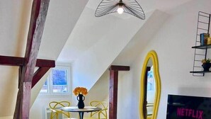 Una sala de estar moderna con un sofá, una mesa de centro, un televisor y un comedor con sillas y una mesa.