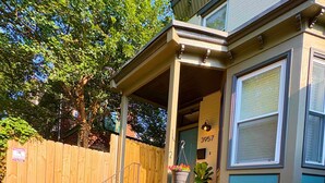 A residential building with a porch, a wooden fence, and a variety of plants. - Amazing 2BdRoom Townhome & Free Street Prkng in the University Section of Philly (Philadelphia)