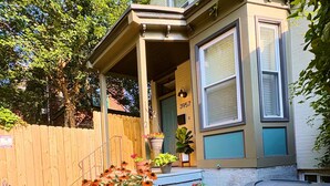 A residential house with a porch, a wooden fence, and various potted plants. - Amazing 2BdRoom Townhome & Free Street Prkng in the University Section of Philly (Philadelphia)