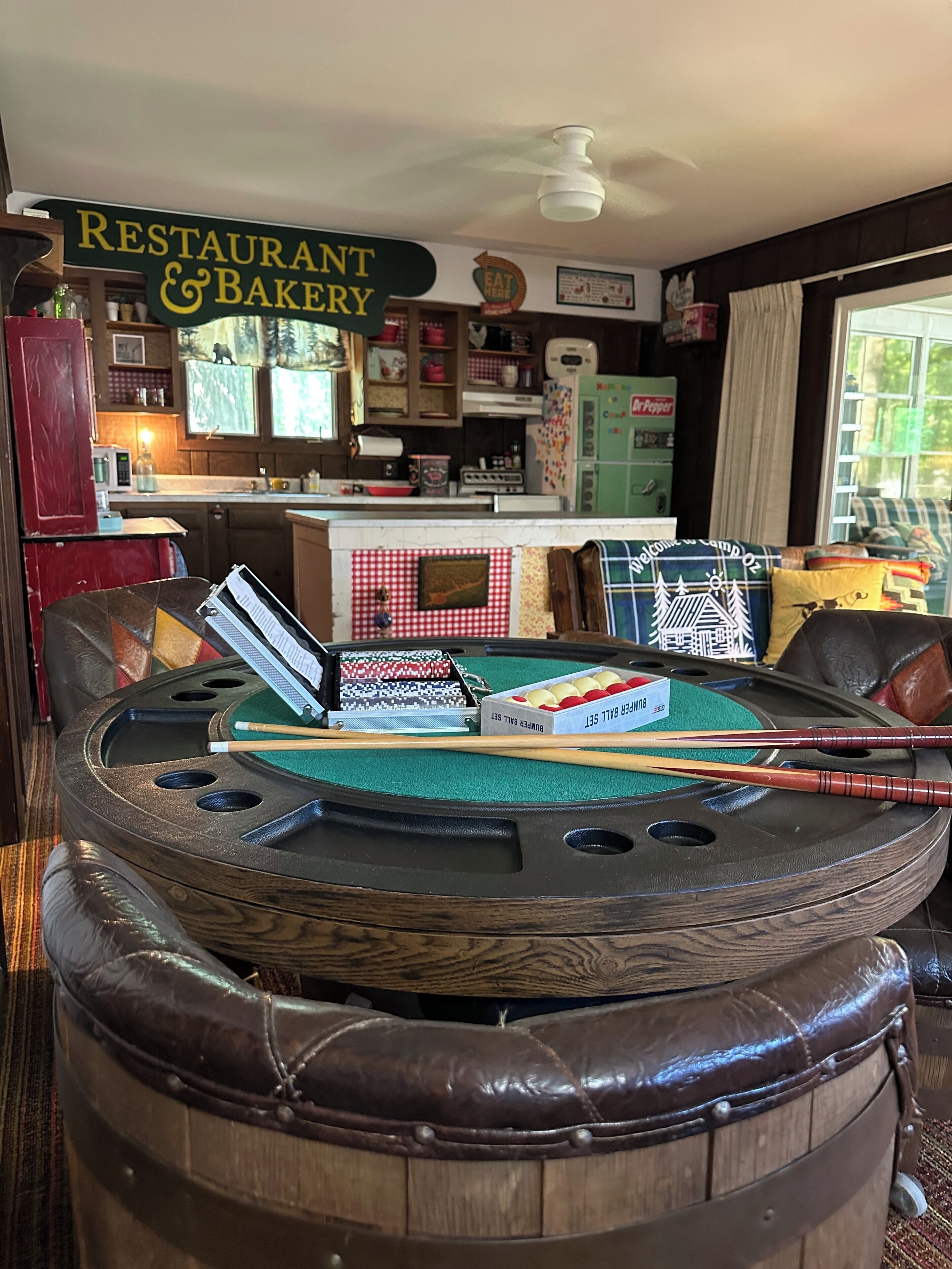 Une table de billard avec des queues de billard, un jeu de billard et une enseigne pour un restaurant et une boulangerie.