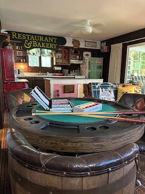 Une table de billard avec des queues de billard, un jeu de billard et une enseigne pour un restaurant et une boulangerie.
