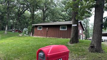 A small brown building with a red mailbox labeled '2202' in front.
