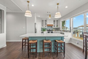 A modern kitchen with a large island, bar stools, and a view of the outdoors. - Lakefront Getaway w/ Hot Tub, Kayaks & Spacious Deck (Crosby)
