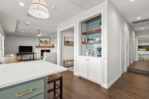 A modern kitchen with white cabinetry, a large island, and a built-in wine rack. - Lakefront Getaway w/ Hot Tub, Kayaks & Spacious Deck (Crosby)