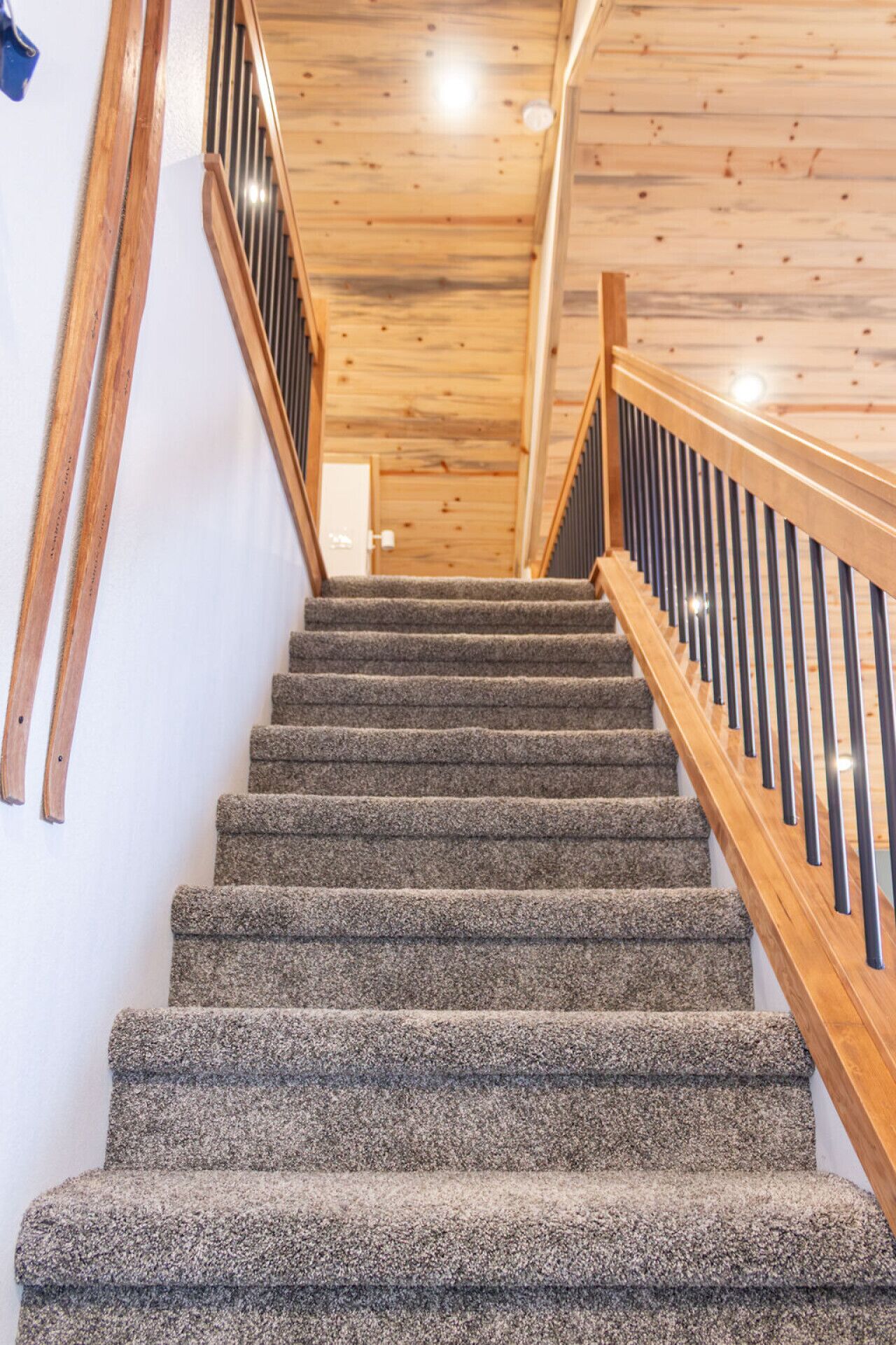 A staircase with carpeted steps and wooden railings.