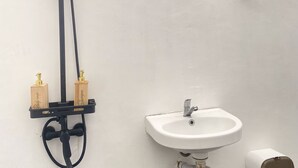 A bathroom with a shower, two soap dispensers, a sink, and a hairdryer. - Ohara Glamping (Kintamani)
