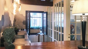 Une pièce avec un plafond en bois, une grande fenêtre, une table et une lampe.