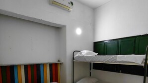 A bunk bed room with a single bed and a bunk bed. There is a wall-mounted air conditioner above the single bed. - Villa Mary Hostel (Taganga) (Taganga)