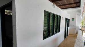 A corridor with white walls, green window shutters, and a wooden ceiling. - Villa Mary Hostel (Taganga) (Taganga)