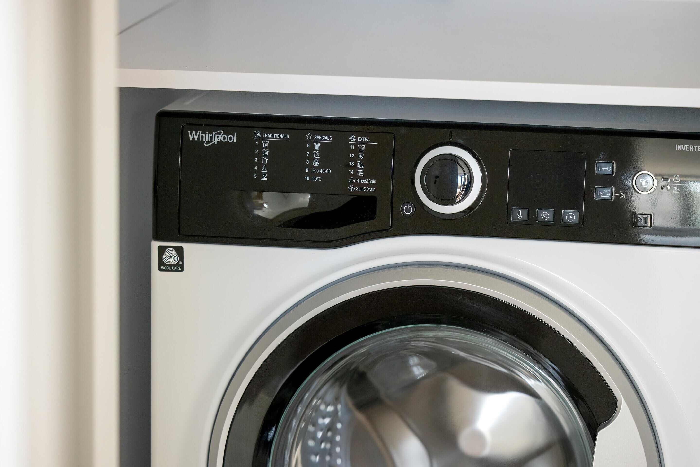 A front view of a Whirlpool washing machine with a control panel displaying various settings and options.