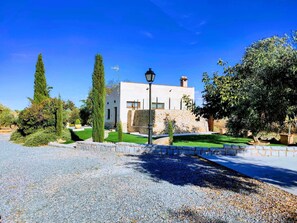 A modern house with a stone facade, a well-maintained lawn, and a gravel driveway.