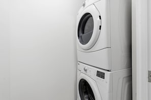 A stacked washer and dryer unit in a room. - Cityscape Haven 2BR with Fantastic CN Tower View (Toronto)