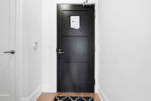 A black door with a check-out sign, a keypad lock, and a small window. - Cityscape Haven 2BR with Fantastic CN Tower View (Toronto)