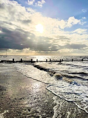 A beach with waves, a wooden jetty, and a cloudy sky. - The Paddocks - A charming coastal holiday home in Heacham, Norfolk (Heacham)