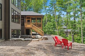 Une cabane à deux étages dotée d’une terrasse en bois et d’un escalier menant à l’étage supérieur.