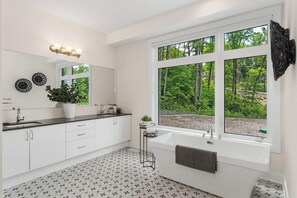 Une salle de bain moderne avec une grande fenêtre, une baignoire et un lavabo.