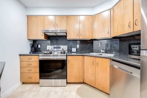 The full stock kitchen boasted gleaming stainless steel appliances, ample counter space, and every culinary tool imaginable, ensuring every meal was a gourmet delight. - Modern 1BR/1BA condo near Downtown with City Views (Toronto)