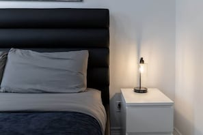 The bedroom, adorned with tasteful decor, centered around a luxurious king-size bed, inviting rest and relaxation in a haven of comfort and style. - Modern 1BR/1BA condo near Downtown with City Views (Toronto)