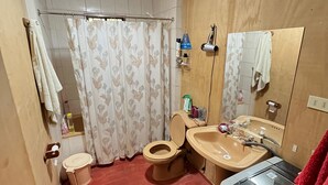 A compact bathroom with a toilet, sink, and shower area. - Black Stone (Licanray)