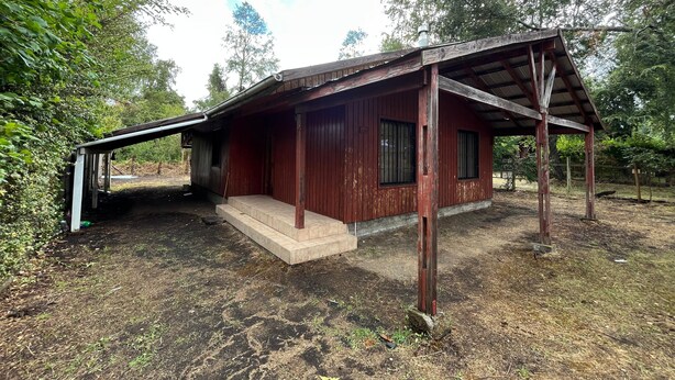 A rustic wooden cabin with a slanted roof, a small porch, and a dirt ground. - Black Stone (Licanray)