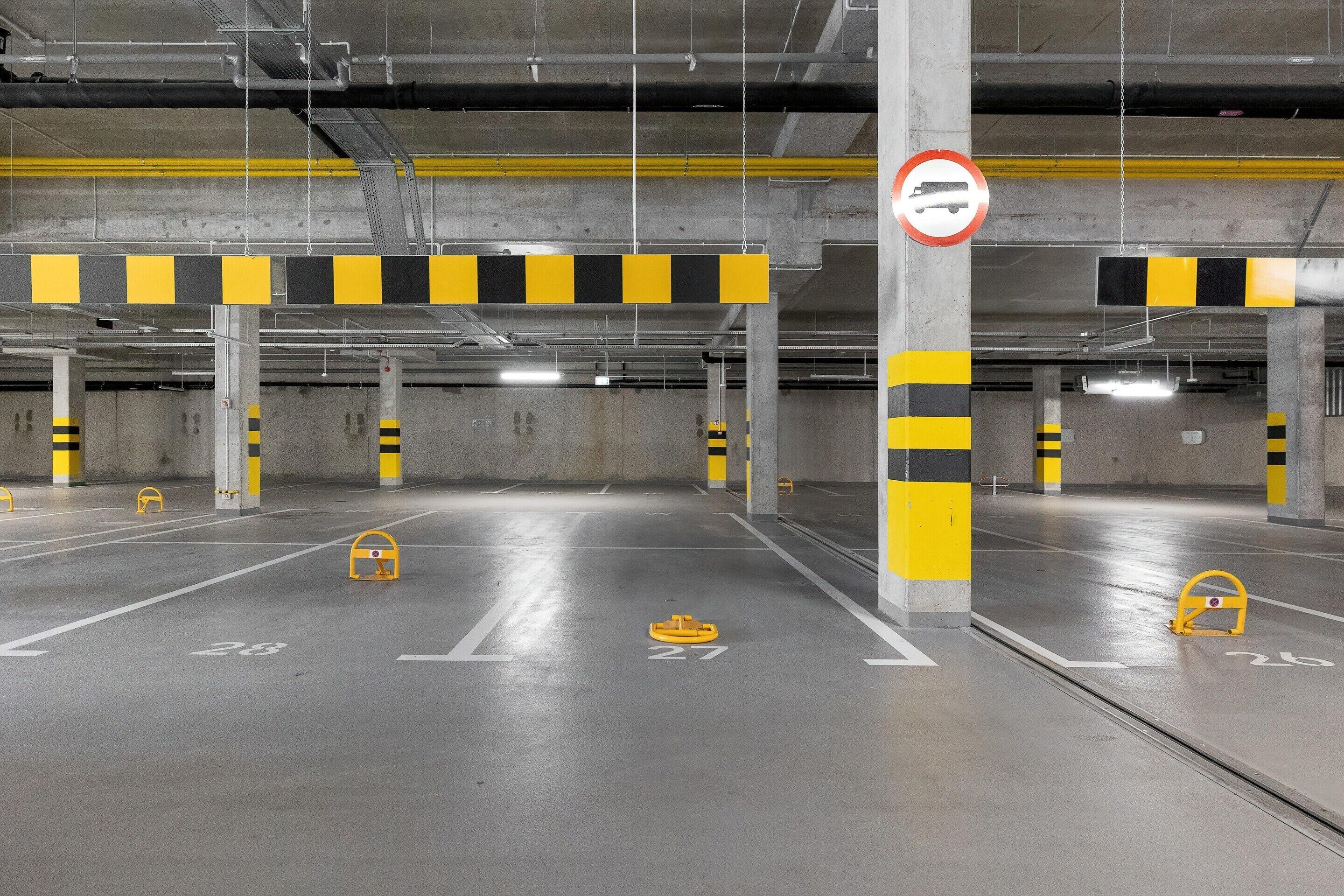 A multi-level parking garage with clearly marked parking spaces and a no-parking sign.