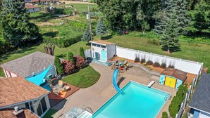 A residential property with a swimming pool, a small shed, and a well-maintained lawn. - Maplewood Getaway | Sauna & Bar (Maplewood)