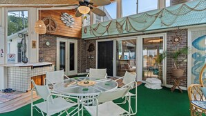 An outdoor patio area with a round table and chairs, a ceiling fan, and a decorative netted ceiling. - Maplewood Getaway | Sauna & Bar (Maplewood)