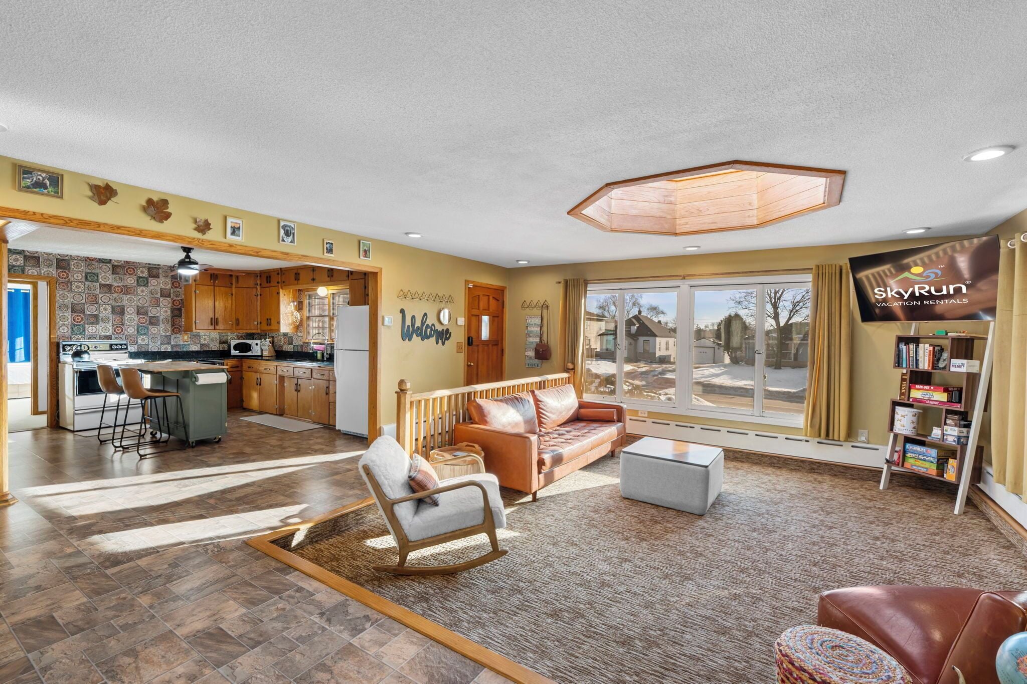 Relax in this spacious open-concept living area where warm wood and leather create the perfect retreat atmosphere for your group getaway.