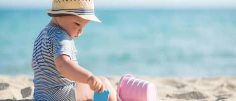 A child playing with sand toys on a beach.