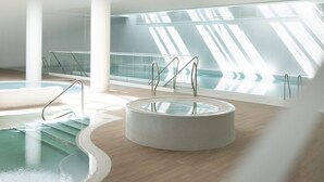 A modern indoor swimming pool with clear glass walls, a wooden floor, and a circular hot tub. - Stunning Seaview Retreat for 4 in Pobierowo (Rewal)