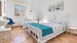 Un dormitorio con cama, escritorio, silla y ventana.