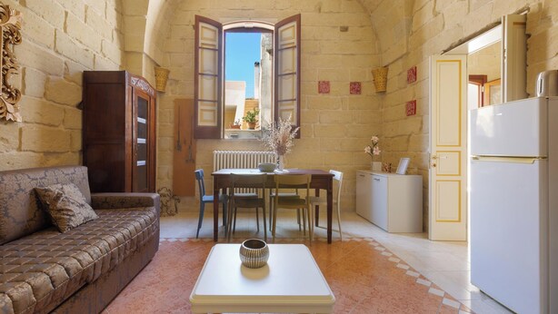 A compact kitchen with a dining table, chairs, a sofa, and a refrigerator. - Acamya by BarbarHouse (Acaya)