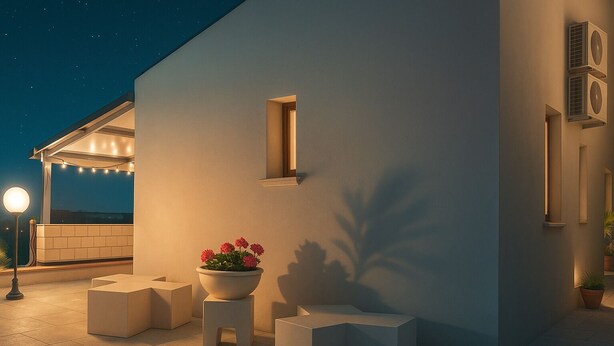 An outdoor patio area with a modern design, featuring a seating arrangement, a potted plant, and a string of lights. - Comfortable family cottage in the midst of nature (San Cataldo)