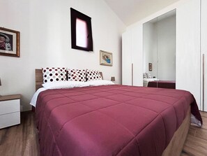 A bedroom with a large bed, a nightstand, a dresser, and a mirror. - Comfortable family cottage in the midst of nature (San Cataldo)