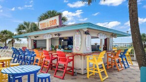 Eine Tiki-Bar mit Außenbestuhlung und einer Speisekarte.