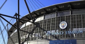 Das Äußere des Etihad Stadiums, mit deutlicher Ansicht des Manchester City Logos und des Stadionnamens.