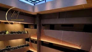 A multi-level atrium with tiered seating and greenery. - LM BEACH HAUS (João Pessoa)