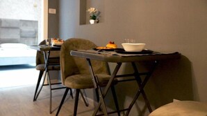 Moderni ruokailutila, jossa on kahdelle katettu pöytä, ja pöydällä on kulho sekä lautanen, jossa on ruokaa.