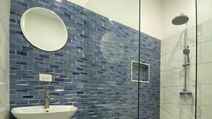 Un baño con lavamanos, espejo y ducha.