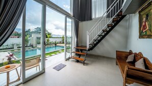 A spacious room with a large sliding glass door leading to a pool area, a wooden bench, and a staircase with a railing. - Hayana Villa Kintamani (Kintamani)