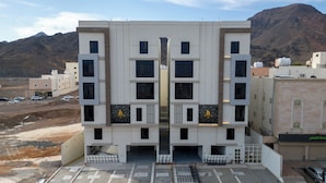 Un edificio moderno con fachada simétrica, múltiples ventanas y una entrada central.