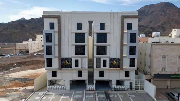 Un edificio moderno con fachada simétrica, múltiples ventanas y una entrada central.
