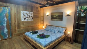 Una habitación de madera con una cama, obras de arte y una estantería con una planta.