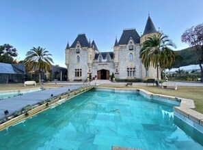 Un gran edificio de piedra con piscina delantera.